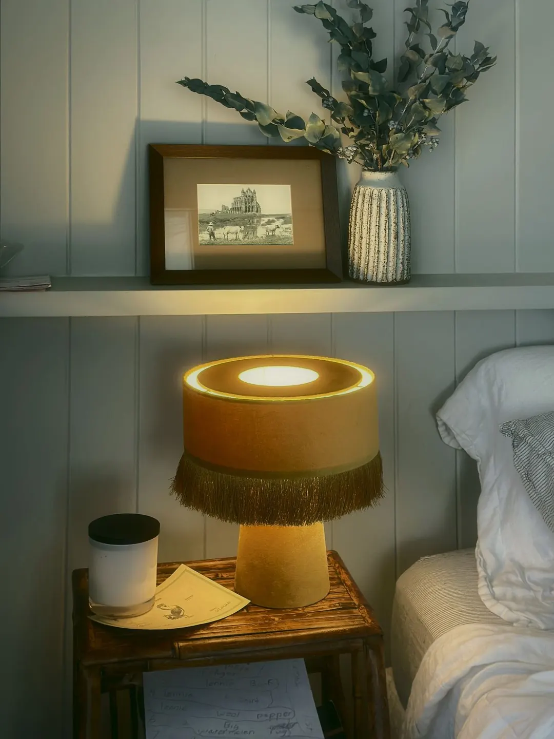 Fringed lamp on a bedside table against VJ boards