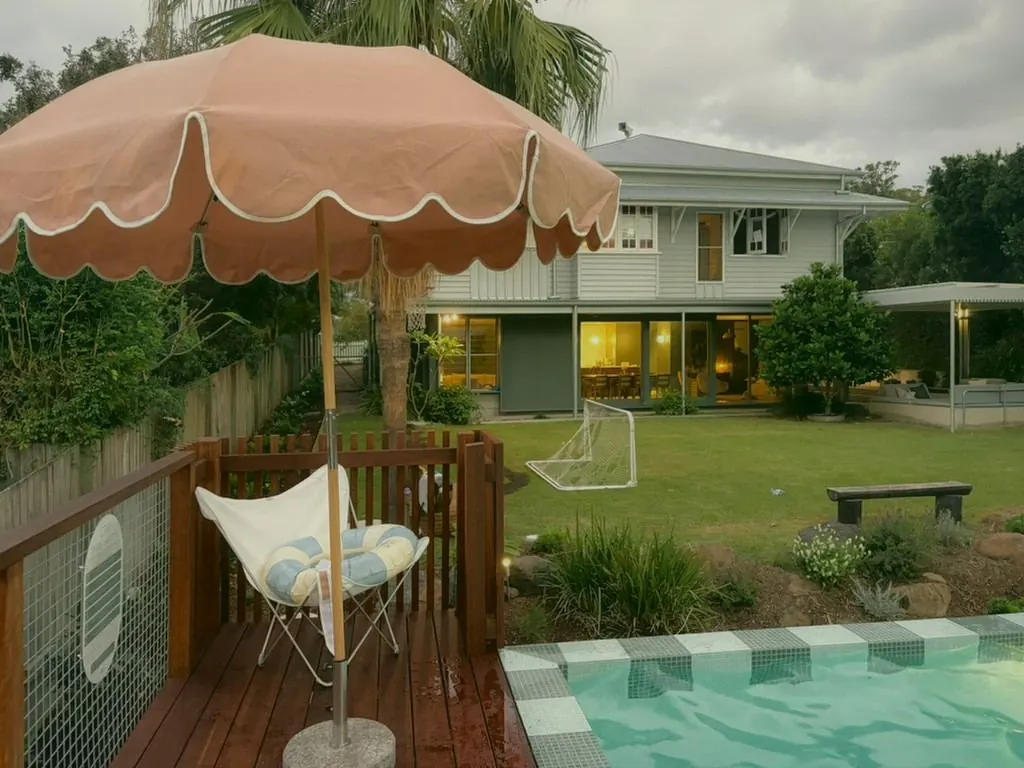 Timber deck with a pink scalloped umbrella beside the plunge pool